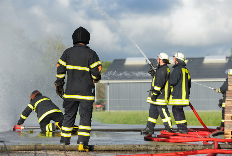 Szenisches Foto von Personen im Löscheinsatz zur Illustration der Leistungen im Bereich Brandschutz